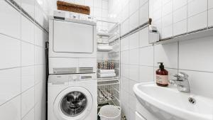 ein weißes Badezimmer mit einer Waschmaschine und einem Waschbecken in der Unterkunft Luxurious w/ beautiful location in Bergen