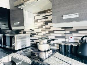 a kitchen with a counter with a stove top oven at Shazeal Apartment Tipton in Ocker Hill