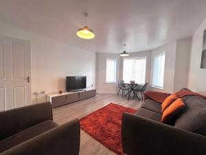 ein Wohnzimmer mit einem Sofa und einem Flachbild-TV in der Unterkunft Shazeal Apartment Tipton in Ocker Hill