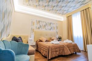 モンテカティーニ・テルメにあるHotel Ariston & Spaのベッドルーム1室(ベッド1台、青い椅子付)
