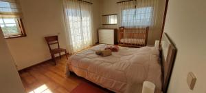 a bedroom with a bed and a crib in it at Lagoon & Country Side Home in Ílhavo