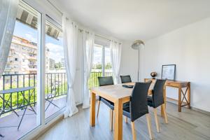 comedor con mesa y sillas y balcón en Confortable 2 pièces 54 m2 proche de la mer, en Niza