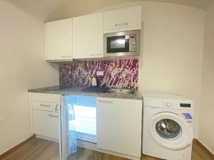 een keuken met een wasmachine en een magnetron bij Washingtonova apartment 006 in Praag