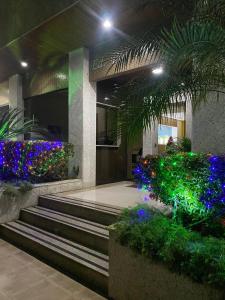 un bâtiment avec des escaliers et des fleurs et des plantes colorées dans l'établissement Alugo apartamento de luxo, 3 quartos, 2 vagas, à Cabo Frio