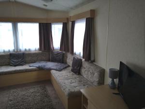 a living room with a couch and a television at Caravan for hire in Lancaster