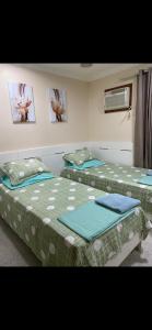 Cette chambre comprend 2 lits jumeaux et un ventilateur. dans l'établissement Alugo apartamento de luxo, 3 quartos, 2 vagas, à Cabo Frio