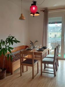 a dining room with a table and chairs and a potted plant at Schöne helle Wohnung mit Whirlpoolbadewanne in Graz