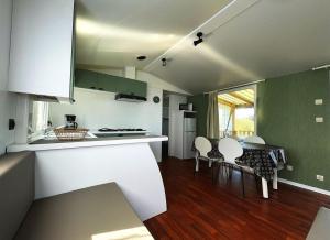 a kitchen and dining room with a table and chairs at Bungalow Breizh Vue in Plouha
