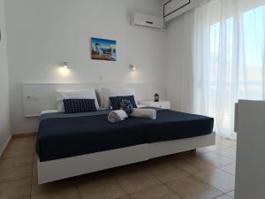 a bedroom with a large bed with blue pillows at Nautilus City Studios & Apartments in Rhodes Town