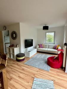 貝西格海姆的住宿－Ferienwohnung am Wartturm，带沙发和红色椅子的客厅