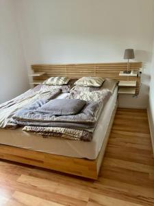 een groot bed met een houten hoofdeinde in een slaapkamer bij Ferienwohnung am Wartturm in Besigheim