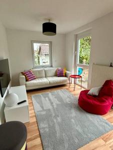 a living room with a couch and a red chair at Ferienwohnung am Wartturm in Besigheim