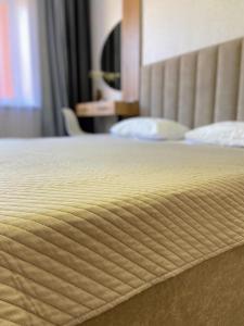 a close up of a bed in a hotel room at 1-ком Костанай Плаза in Kostanay