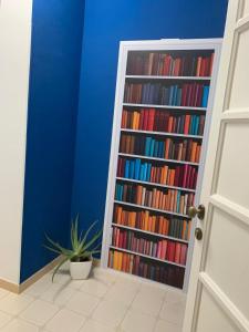 un estante lleno de libros junto a una puerta en The Apartments Nordino, en Mazara del Vallo