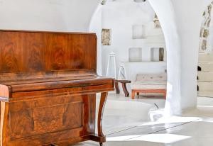 um piano de madeira numa sala com uma cadeira em Villa Ravino Secret Retreat em Ischia