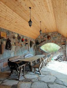 uma sala de pedra com uma mesa de madeira e bancos em DOM GOŚCINNY NAD JEZIOREM BIAŁYM em Gorzewo