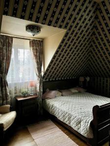 um quarto com uma parede de madeira, uma cama e uma janela em DOM GOŚCINNY NAD JEZIOREM BIAŁYM em Gorzewo