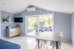 a living room with a table and chairs and a tv at Maison au bord du Loir in La Flèche