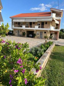 a large building with flowers in front of it at Flo's Apartments in Mesolongion