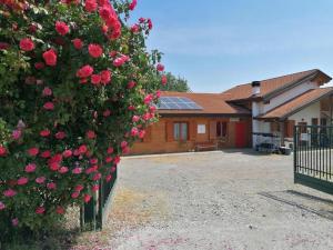 a hedge of roses in front of a house at Agriturismo bio Apipoli in Lucino