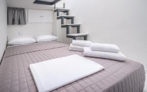 1 dormitorio con 2 camas y toallas blancas. en Avgoustinos house, en Chios