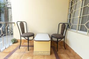 two chairs and a trash can on a balcony at Hotel Telehaus International in Bangalore