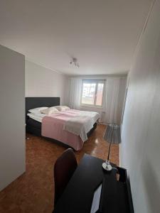 1 dormitorio con 1 cama y 1 mesa con lámpara en M:Hamn Centrum, en Mariehamn