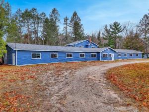 un edificio azul en medio de un campo en 2 Queen Beds - Room 3, en Houghton Lake