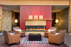 a lobby with a fireplace and chairs and a table at Sheraton Anchorage Hotel in Anchorage