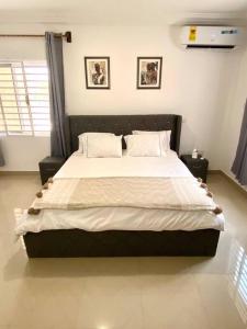 a bedroom with a large bed with two pillows at Spacious 2 Bedroom House East Legon Accra in Accra