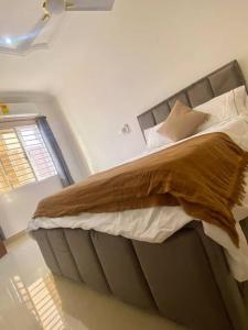a bedroom with a large bed with a brown blanket at Spacious 2 Bedroom House East Legon Accra in Accra