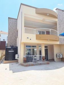 a large house with a balcony on top of it at Spacious 2 Bedroom House East Legon Accra in Accra