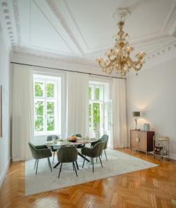 ein Esszimmer mit einem Tisch, Stühlen und einem Kronleuchter in der Unterkunft Roosevelt Stadthaus in Wien