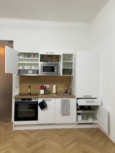 ウィーンにあるApartment Viennaの小さなキッチン(白いキャビネット、電化製品付)