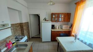a kitchen with a white refrigerator and a table at Tapolcai Hostel in Tapolca