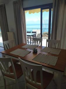 uma mesa de jantar com vista para o oceano em Όμορφο διαμέρισμα με εκπληκτική θέα em Menídion