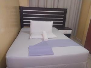 a bed in a room with purple sheets and pillows at M-Dee Guest Pass Lodge in Phuthaditjhaba