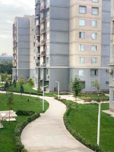 een loopbrug in een park voor een gebouw bij - Cozy Apartment in Quite Area - in Tasjkent