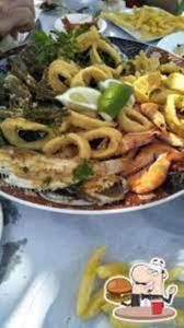 dos platos de comida en una mesa con aros de cebolla en Ras El Ma Center Family Appartment, en El Borj