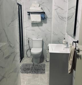 a white bathroom with a toilet and a sink at Beautiful 1-Bed Apartment in Aldeia de Paio Pires in Aldeia de Paio Pires