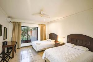 Cette chambre comprend 2 lits et une fenêtre. dans l'établissement Hotel Caña Brava Inn, à Cañas