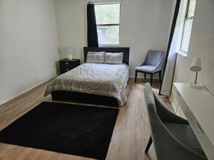1 dormitorio con 1 cama y 1 silla en A Secluded Urban Escape en Austin