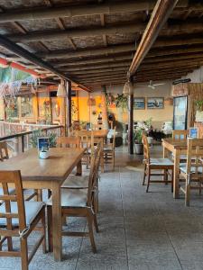 an empty restaurant with wooden tables and chairs at Los Corales in Máncora