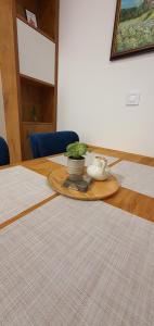 a wooden table with a plate with a plant on it at Studio apartmani Anika in Vrdnik