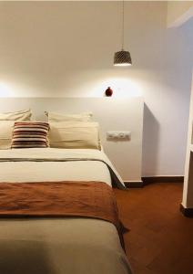 ein Schlafzimmer mit einem großen Bett mit einer Lampe in der Unterkunft MAISON HÔTEL SES PENYES in Alaior
