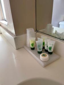 een plank met vier kopjes en een spiegel in de badkamer bij Hotel Pacific Garden in Gardena