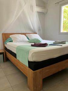 a bedroom with a large bed with towels on it at Douceurs Caraïbes, Gîte Alpinia. in Bouillante