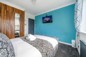 里茲的住宿－*328OL* For your relaxed & Cosy stay + Parking，一间卧室设有一张床和蓝色的墙壁