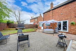 a patio with a grill and chairs and a building at *328OL* For your relaxed & Cosy stay + Parking in Leeds