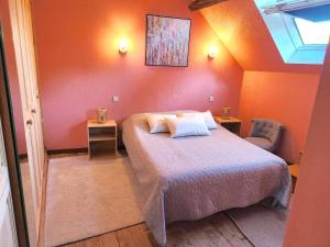 ヴィルフランシュ・ド・ルエルグにあるLa Combe aux oiseauxのベッドルーム1室(オレンジ色の壁のベッド1台付)